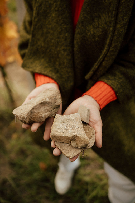 Hands holding pieces of Moravian sandstone, reflecting The Lacery’s connection to the land and its terroir.